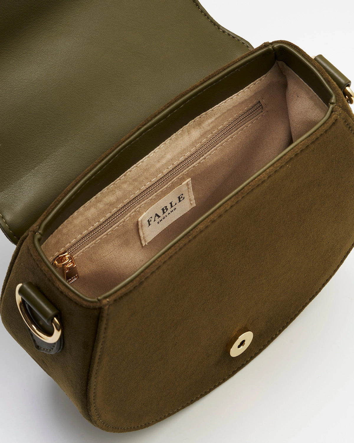 Inside of the saddle bag is green and beige against a white background.