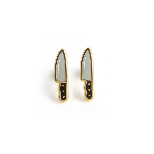 Chef knife style earrings with a silver blade, and a black handle with a small gold outline. Earrings are against a white background