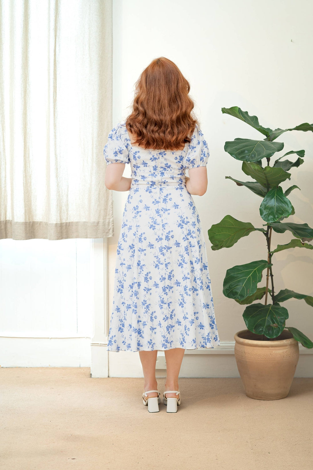 Full body back view of the dress with model against a light background