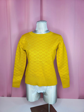 Sweater on mannequin against pink background 