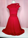 Dress on mannequin against a pink background
