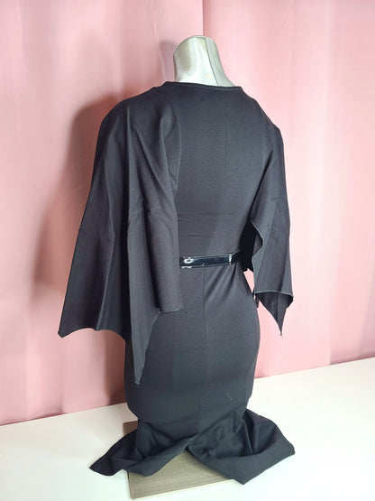 Back of dress at an angle on a mannequin against a pink background 