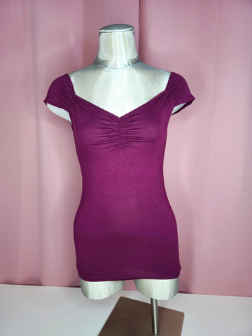 Front of top on a mannequin against a pink background