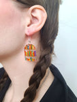 Close-up photo of model wearing bookshelf earrings with plastic hooks
