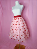 Skirt on a white mannequin against a pink background 