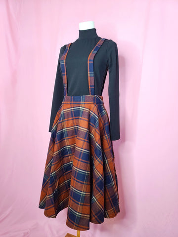 Front of skirt shown with black mock neck top against a pink background