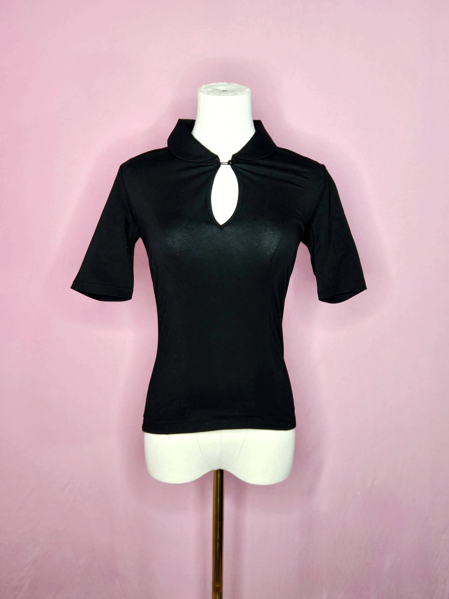 Front of the top on a white mannequin against a pink background