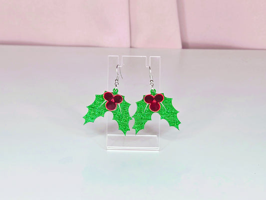 Earrings on a clear earring display against a white and pink background