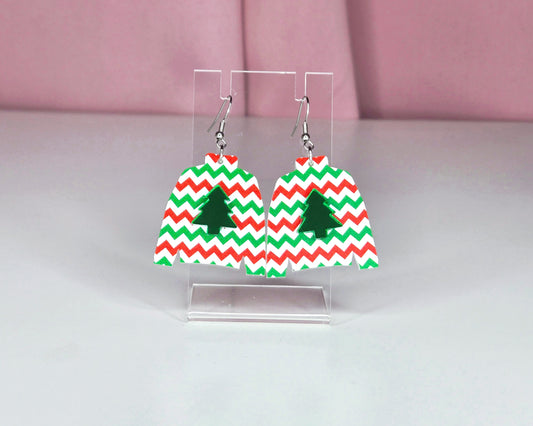 Earrings on a clear earring display against a white and pink background