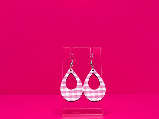 Light punk gingham tear drop earrings on a clear display against a hot pink background.