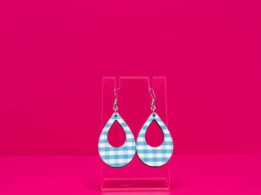 Light blue gingham tear drop shaped earrings on a clear display against a hot pink background.