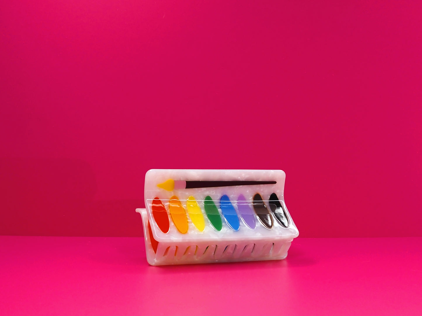 Water color palette haiw claw against a pink background.