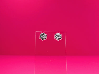 D20 dice earrings on a clear display against a pink background.