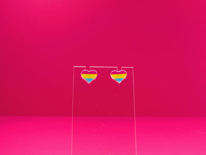 Pansexual pride heart earrings on a clear display against a pink background.