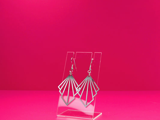 Silver fan earrings on a clear display against a pink background.