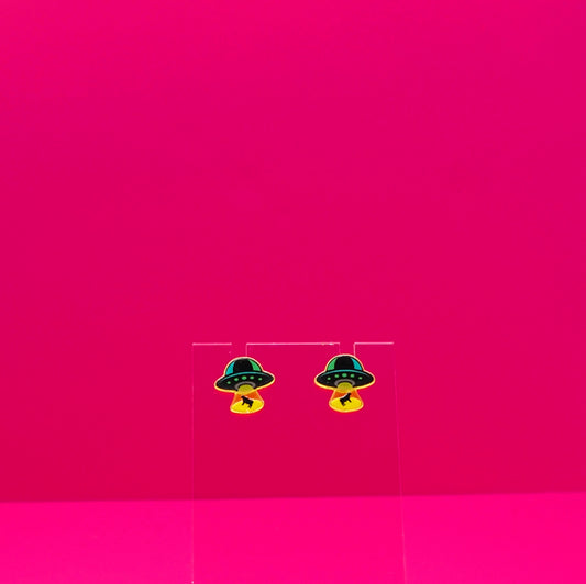 UFO abducting cows on a clear stand against a pink background.