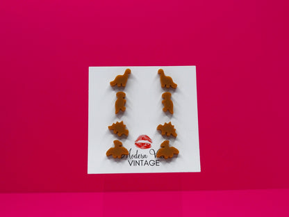 Set of 4 dinosaur earrings on a card with 'Modern Vintage' branding against a pink background.