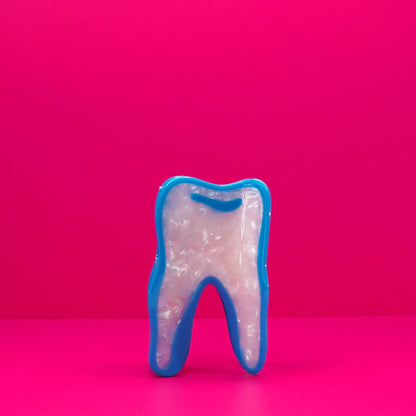 Wisdom tooth hair claw against a pink background.