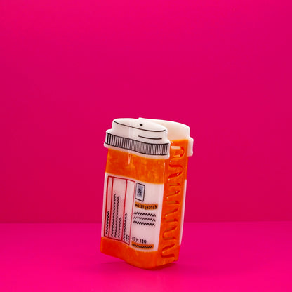 Orange and white prescription bottle hair claw at an angle against a pink background.
