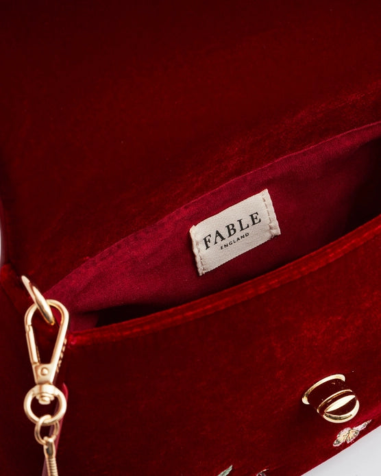 Close up of white interior label "Fable England" on the red purse.