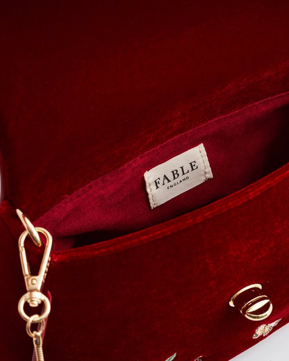 Close up of white interior label "Fable England" on the red purse.
