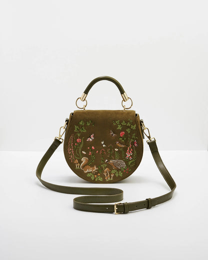 Front of saddle bag with both the handle and the cross body strap against a white background.