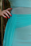 Close up of the mesh on waist of dress. Model has red nails and hand on waist