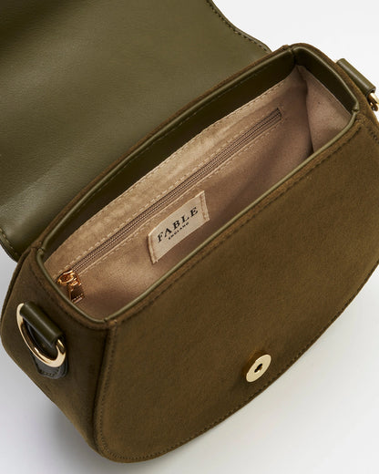 Inside of the saddle bag is green and beige against a white background.