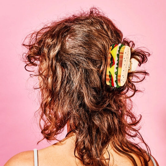 Brunette model with sandwich hair claw against a pink background.