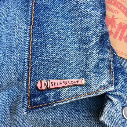 Pink vibrator with 'Self Love' text on a blue denim jacket collar.
