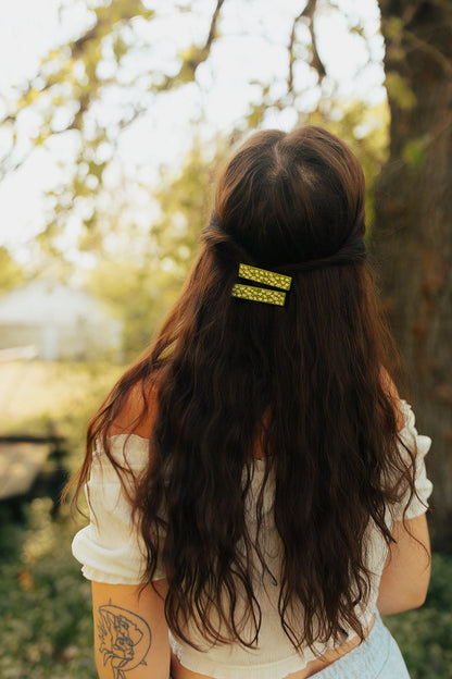 Brunette model wearing both hair clips against a wooded background.