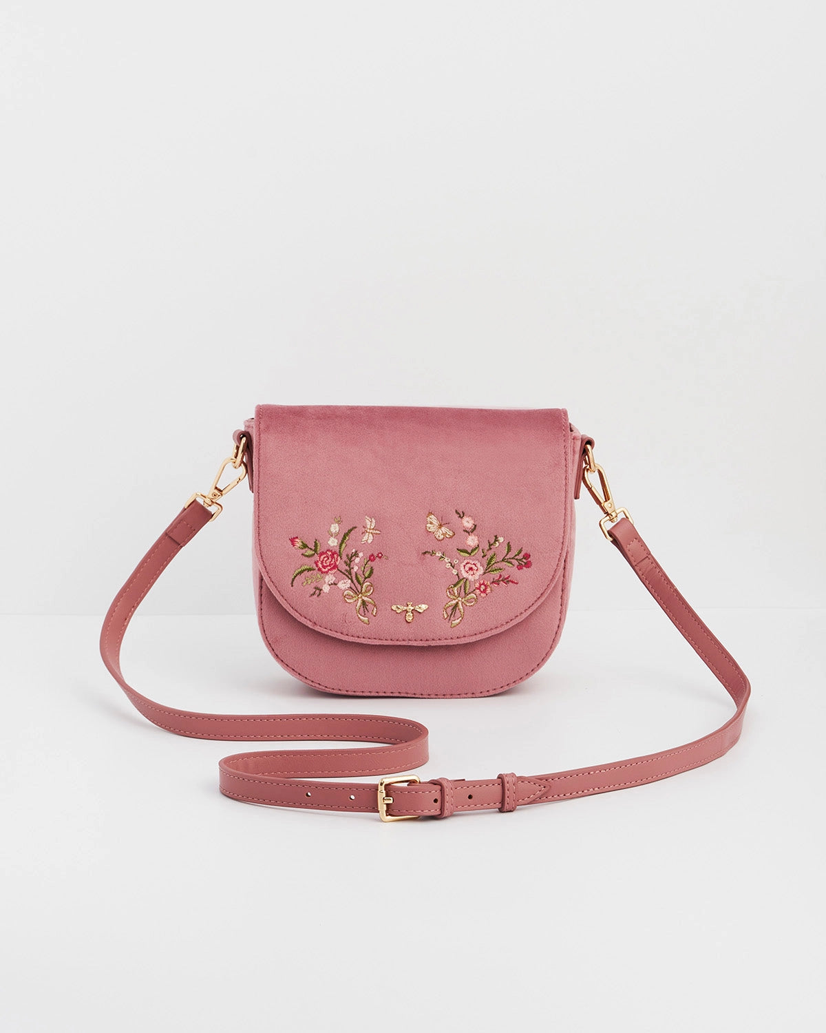 Front of pink saddle bag with pink purse strap against a white background.