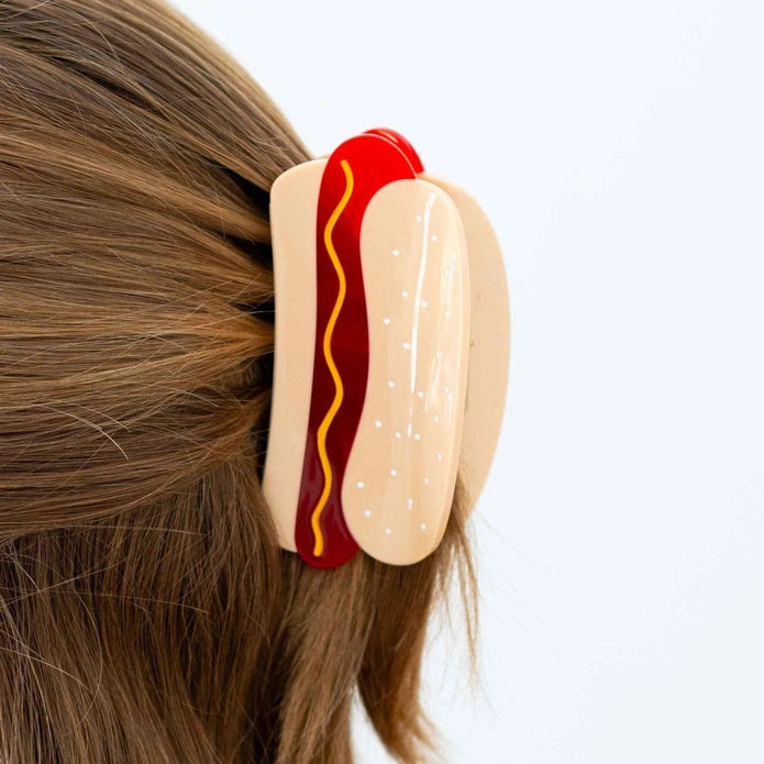 Hair claw shown in action holding up hair against a white background