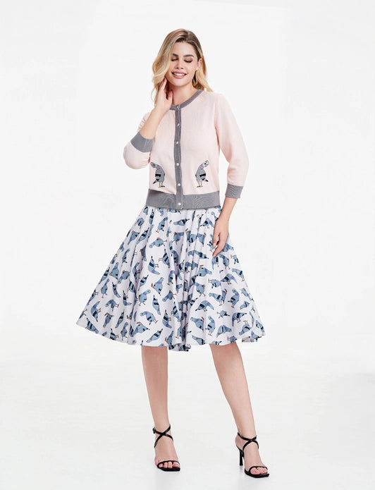 Woman wearing pigeon dress paired with Leslie pigeon cardigan against a white background.