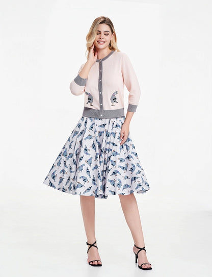 Woman wearing pigeon dress paired with Leslie pigeon cardigan against a white background.