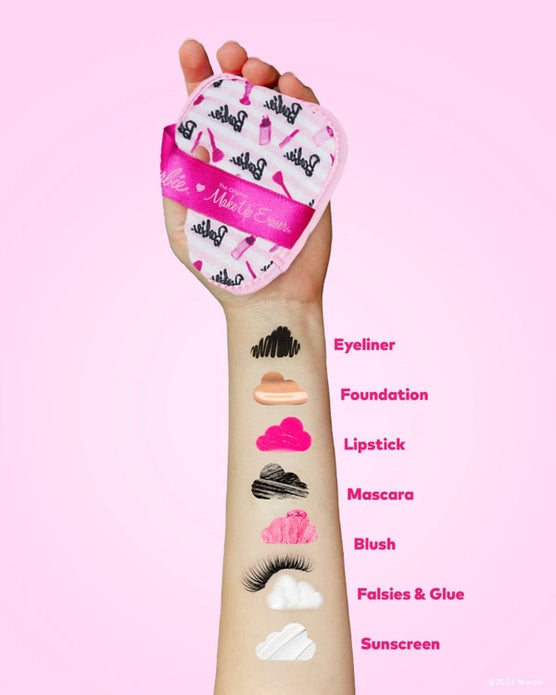 A White model's arm holding a makeup eraser, and the arm shows different makeup products that the makeup eraser erases