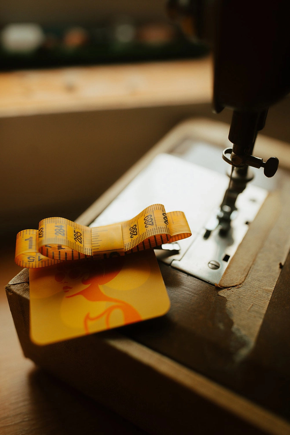 Yellow measuring tape hair bow on a vintage sewing machine.