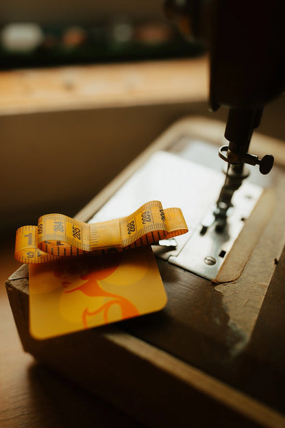 Yellow measuring tape hair bow on a vintage sewing machine.