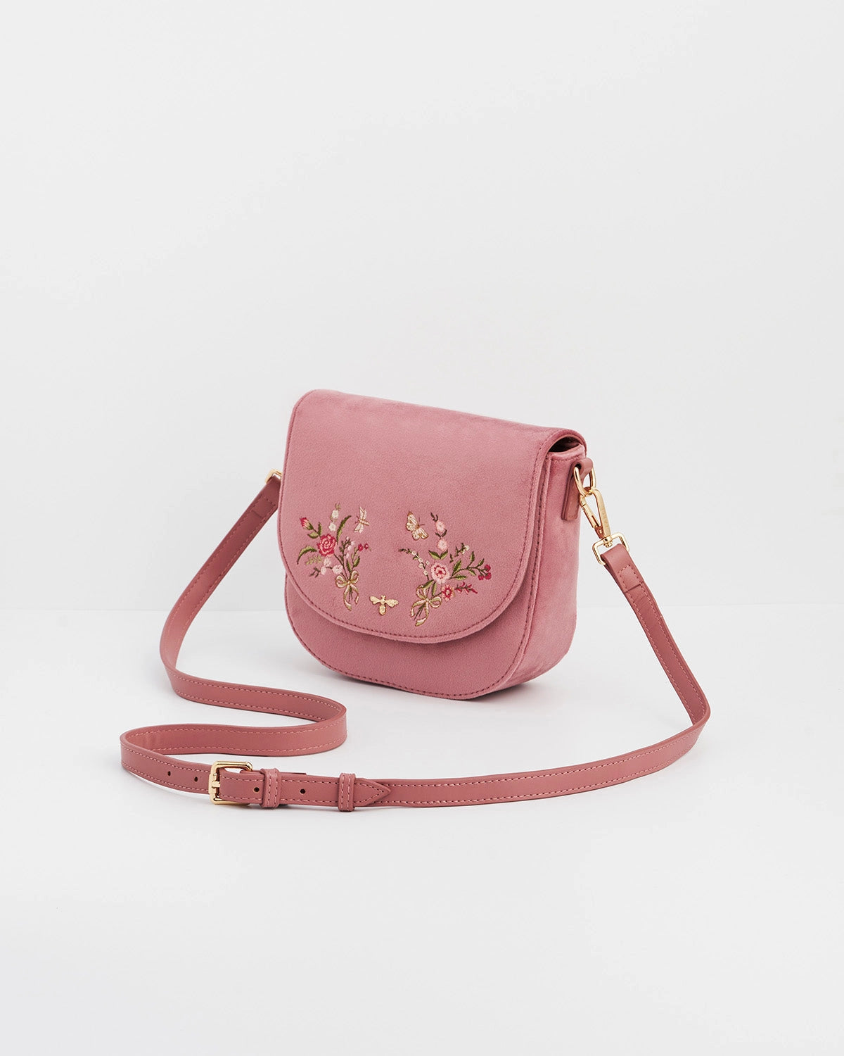 Pink saddle bag with floral details against a white background.