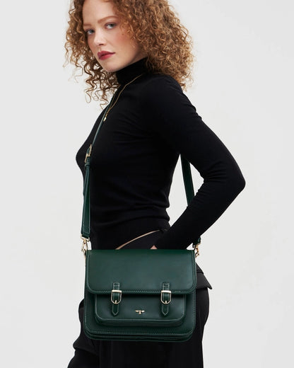 Female model wearing purse across their body against a white background.