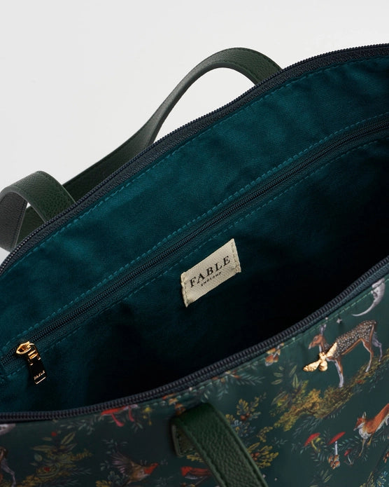 Close up of white label on inside of the bag that states "Fable England". Inside of the tote bag is a plain teal color.