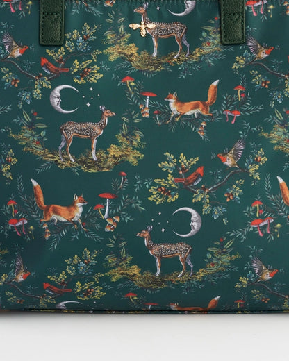 Close up of the red foxes, deer, birds, vintage styled moon, and foliage against a teal-green background.