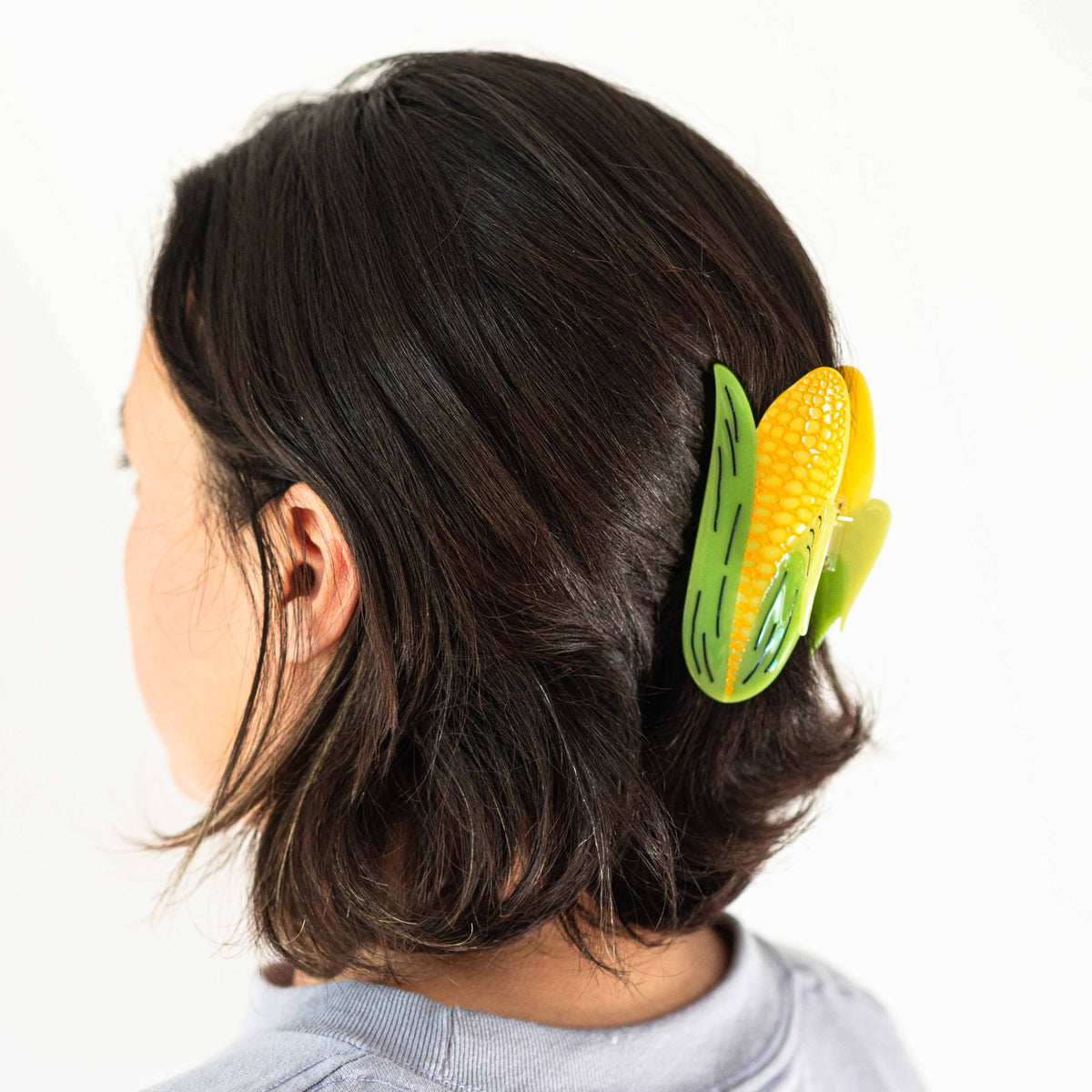 Brunette model with hair claw in hair against a white background.