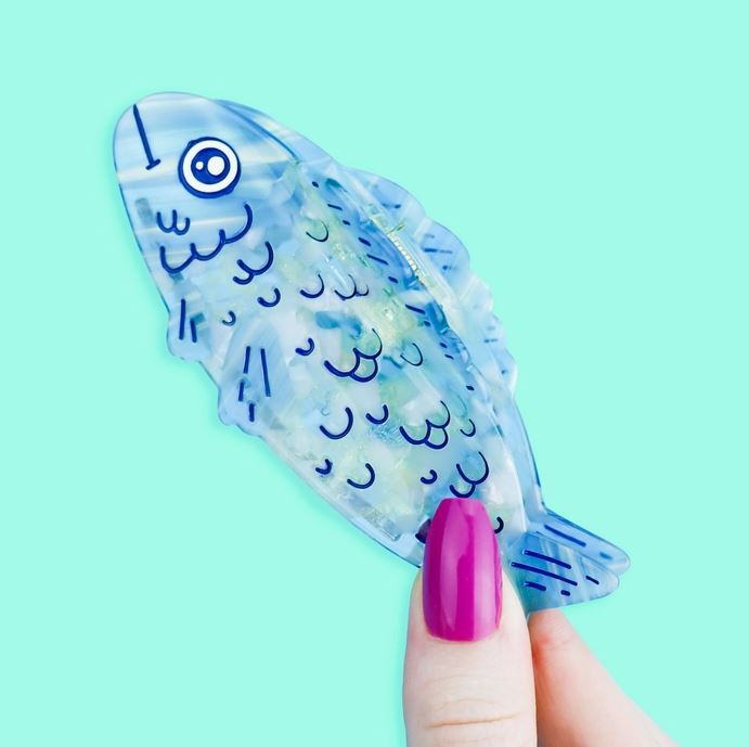 Blue sardine hair claw against a light blue background.
