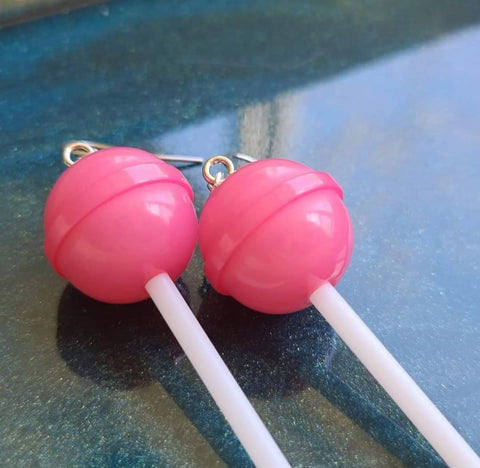 Dark pink earrings on blue background