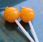 Orange earrings on blue background