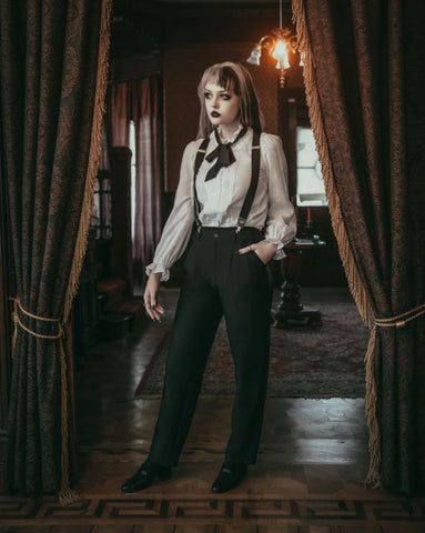 Full body front view of model wearing trousers against a dark academia background