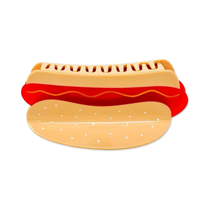 Hot dog hair claw on it's back against a white background.