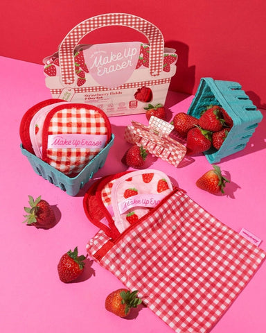 The makeup erasers in strawberry baskets, and some in the wash bag it comes with against a red and pink background