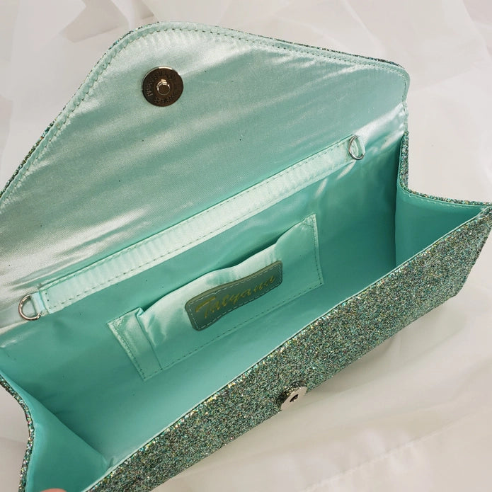 Inside of the clutch showing a light blue inside and a small pocket in the back that is perfect for cards and ids